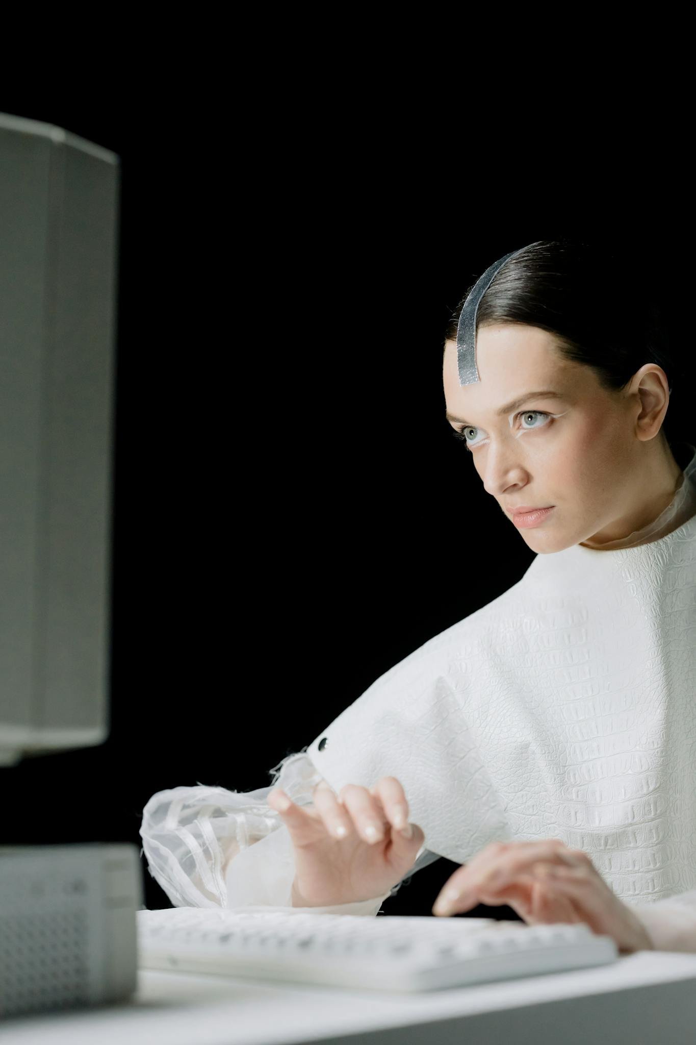 A futuristic woman typing on a vintage keyboard in a high-tech laboratory, showcasing a blend of style and science.